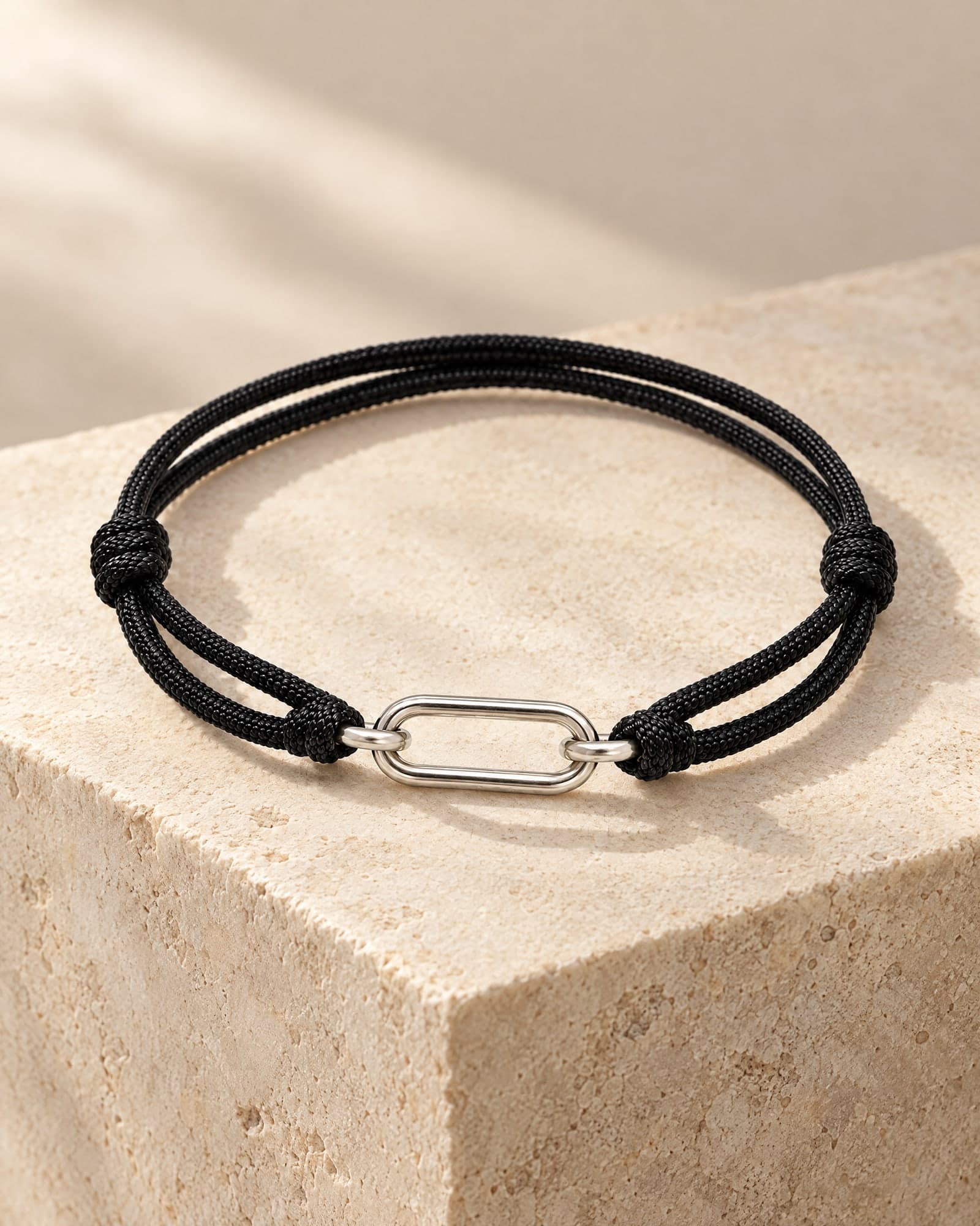 The Pathway in black cord, resting on pale limestone